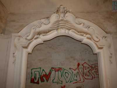 In una di esse spicca un maestoso arco decorativo in rilievo in gesso bianco, anch'esso deturpato da un orrendo scarabocchio